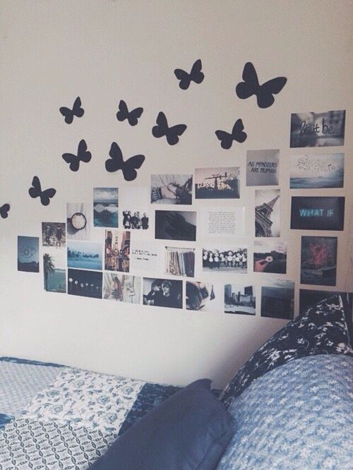 a bedroom with butterflies on the wall and pictures on the wall above it, along with a bed