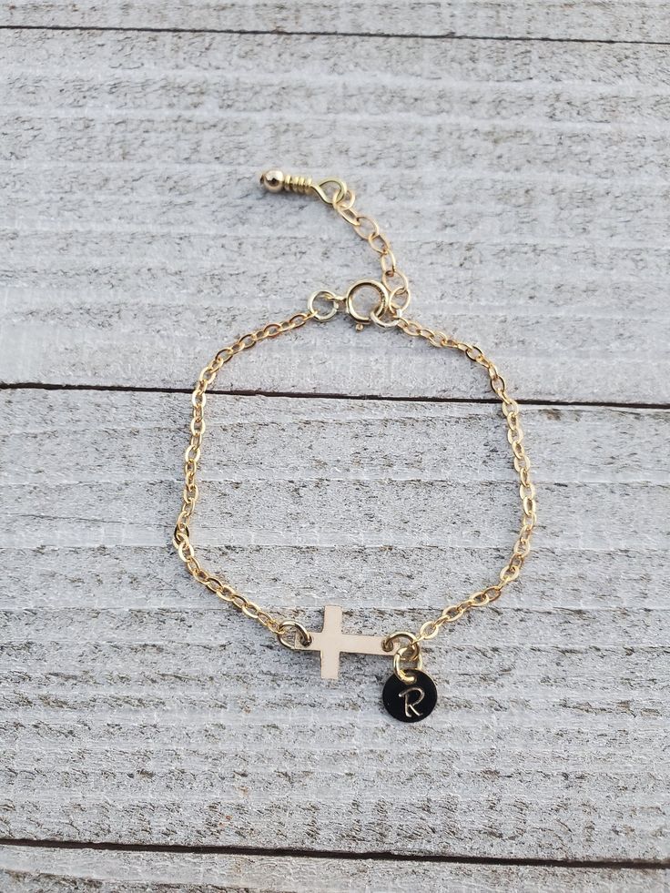 "Gold Cross Baby Bracelet/Baptism Bracelet Baby/Goddaughter Gift/Gift from Godmother Precious and Dainty!! This bracelet is made from 14 K Gold Filled chain. This chain is a sturdy 2x2.5mm. This more robust gauge helps prevent breaking from yanks or tugs from little hands! The Cross is also 14 K Gold Filled as well as the rings connecting the cross to the chain and the disc. The tiny disc, also 14 K Gold Filled, comes stamped with the initial of your choosing. Bracelet also comes with 1 inch ext Personalized Gold Name Bracelet For Baptism, Personalized Gold Rosary Bracelet For Baptism, Adjustable Cross Bracelets For Baptism, Personalized Gold Rosary Bracelet For First Communion, Personalized Dainty Jewelry For First Communion, Dainty Personalized Jewelry For First Communion, Personalized Gold Rosary Bracelet For Birthday, Personalized Gold Jewelry For Baptism, Personalized Cross Rosary Bracelet For Baptism