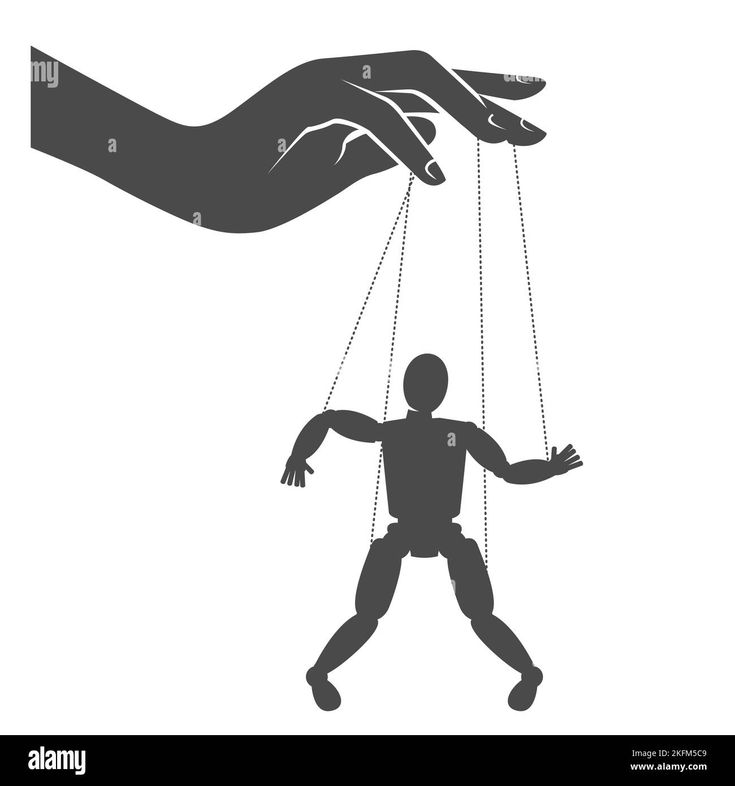 a hand holding a puppet in the shape of a human being suspended by chains - stock image