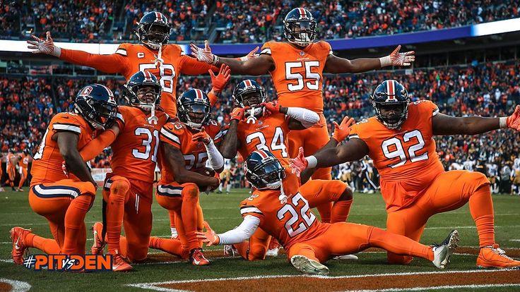 a group of football players on a field with fans in the bleachers behind them