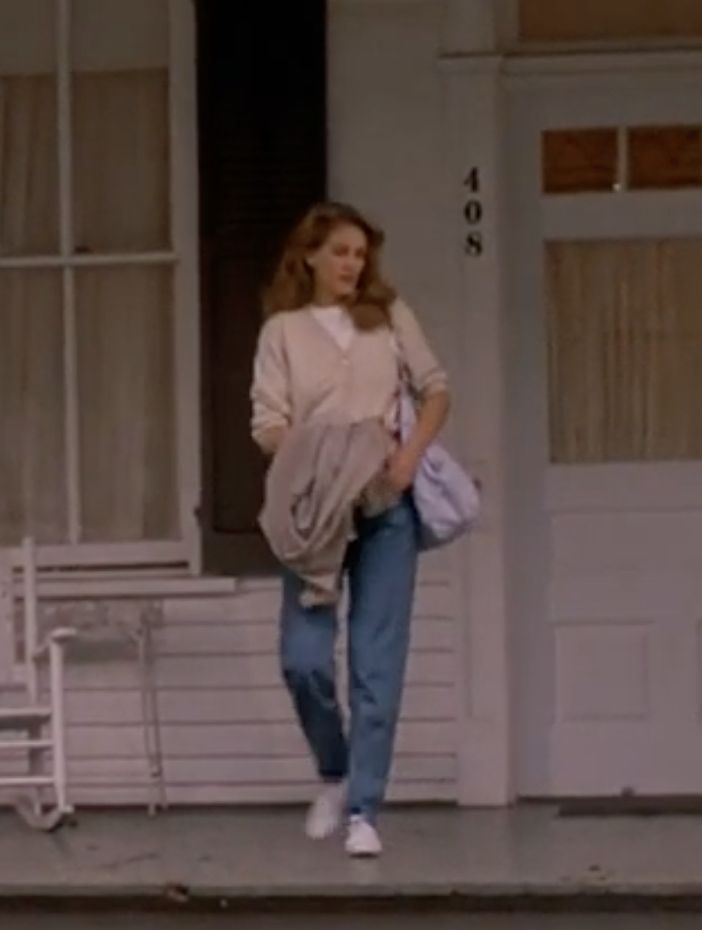 a woman is walking down the steps in front of a house