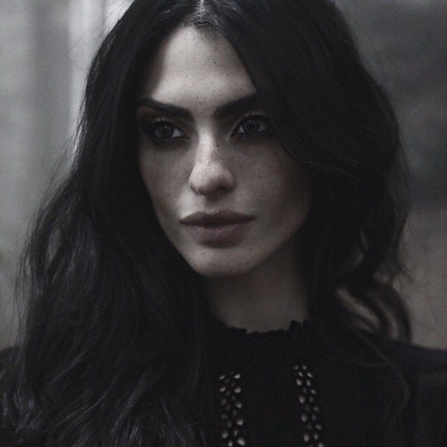 a woman with long black hair and dark eyes