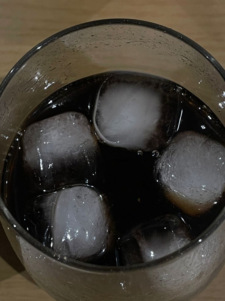 ice cubes in a glass on a wooden table