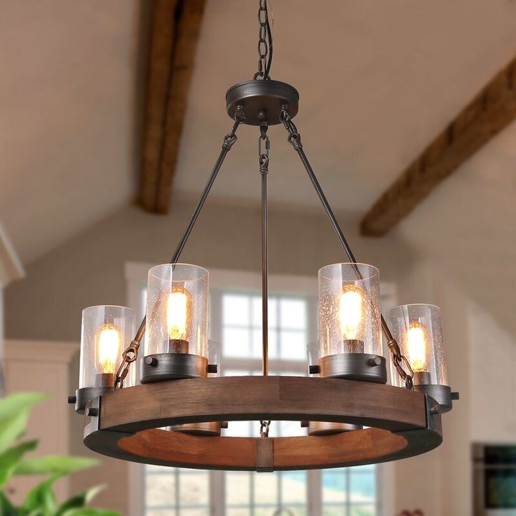 a chandelier hanging from the ceiling in a room with windows and potted plants