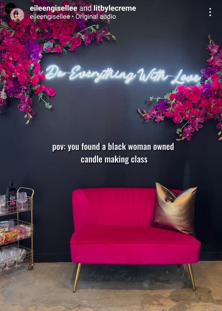 a pink couch sitting in front of a black wall with flowers on it and the words dr energing with love