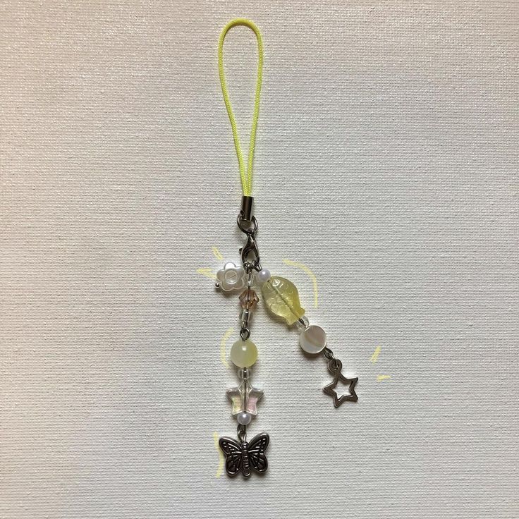 a keychain with a butterfly charm hanging from it's side on a white surface