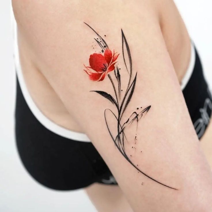 a woman's arm with a red flower tattoo on the left side of her body