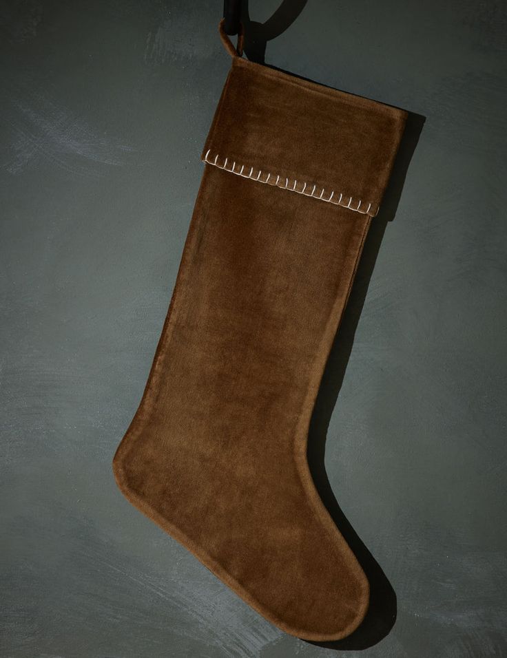 a brown suede christmas stocking hanging on a wall