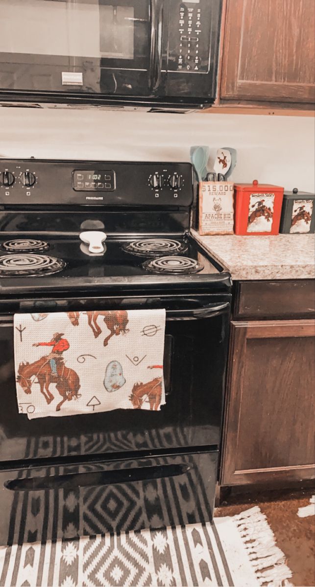 a black stove top oven sitting in a kitchen next to a microwave and countertop