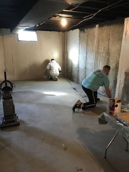 two men are working in an unfinished room