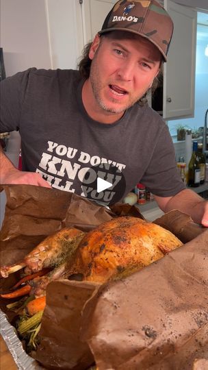 a man holding a turkey in a brown paper bag