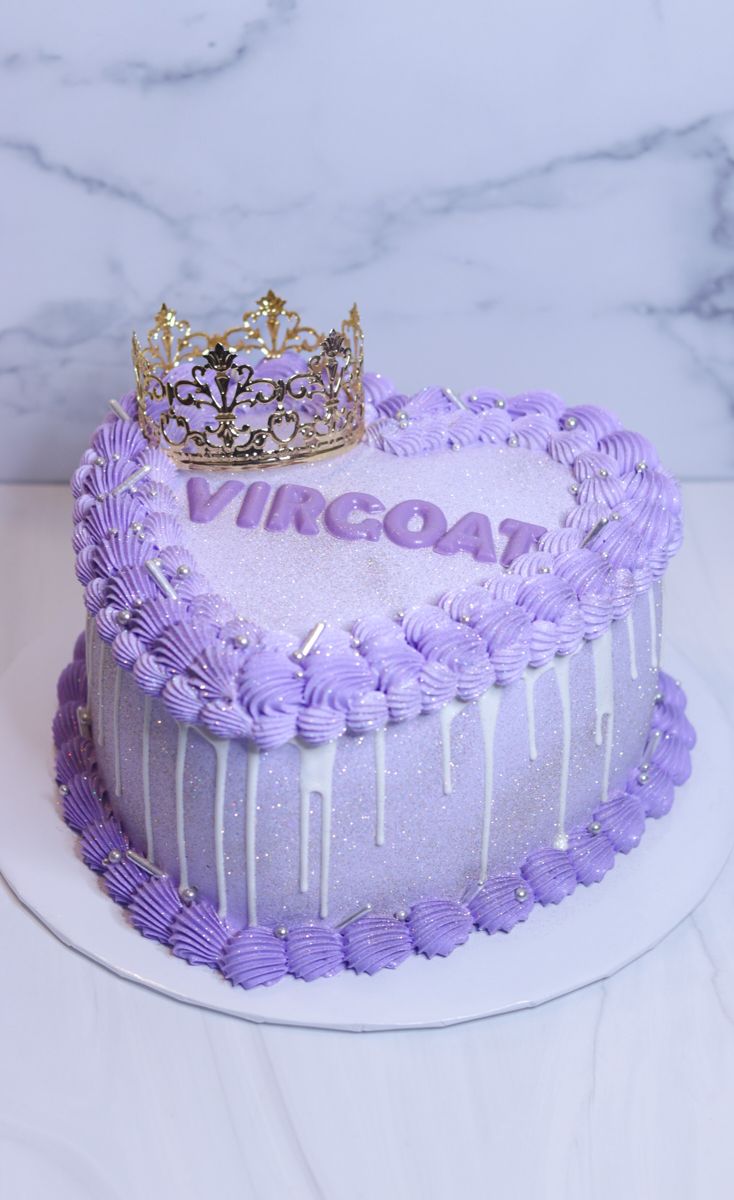 there is a purple cake with a crown on top that says virgoon and has icing dripping from it