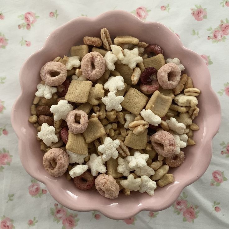 a pink bowl filled with cereal and marshmallows