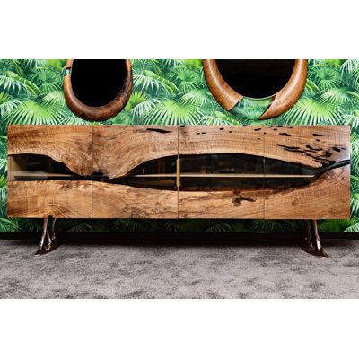 a wooden bench with two mirrors on the wall and palm leaves in the back ground