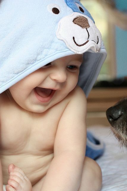 a baby wearing a hat with a dog in front of it and the caption above it