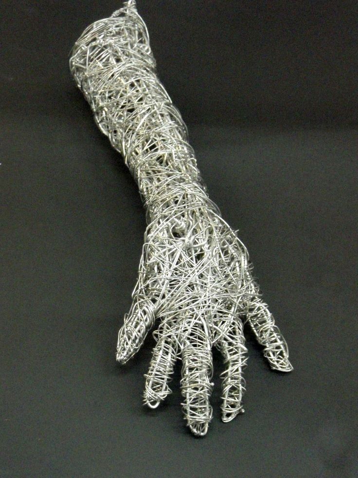 a hand that is made out of silver wire on a black surface with the fingers extended