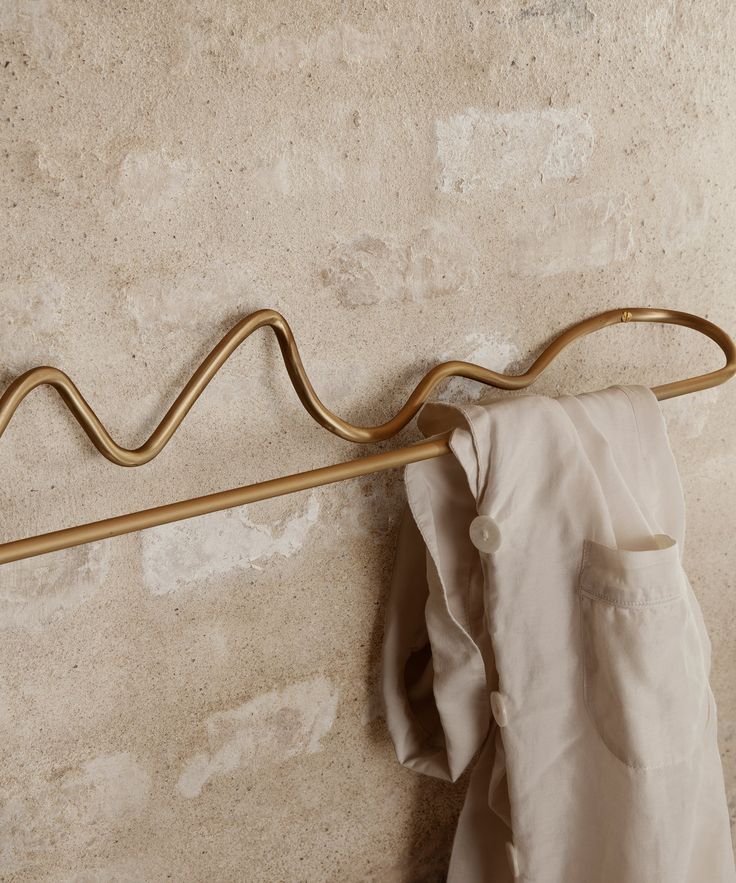 a coat hanger is hanging on the wall next to a white shirt