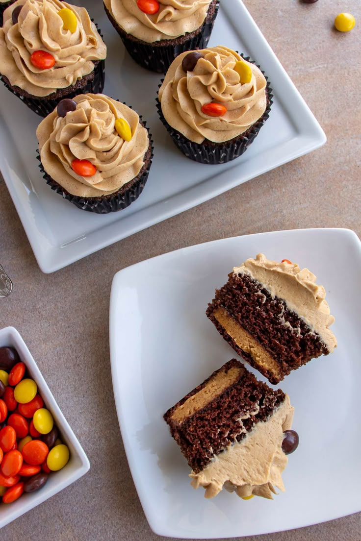 cupcakes with chocolate frosting and candy on plates