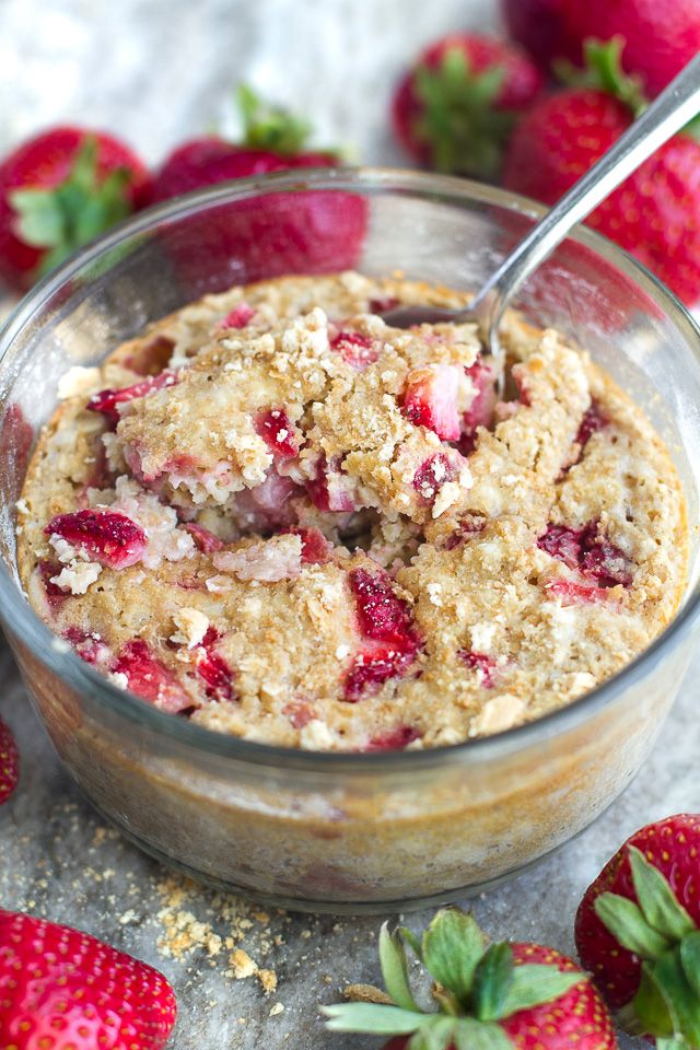 a bowl filled with oatmeal and strawberries on top of a table