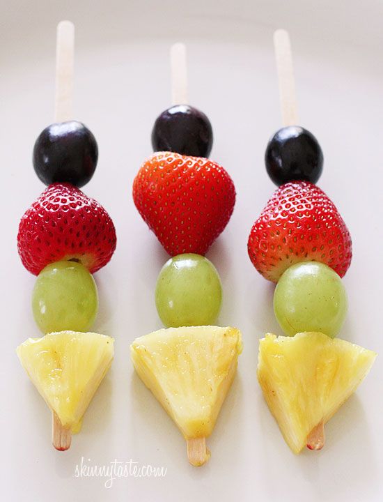 an assortment of fruits arranged on sticks