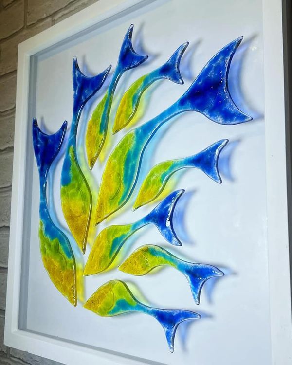 a glass painting with blue, yellow and green leaves