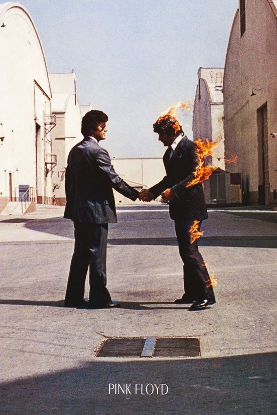 two men in suits shaking hands with fire coming out of their mouths on the street