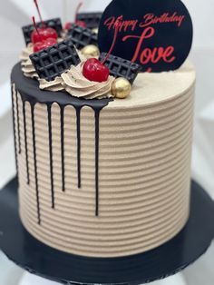 a birthday cake decorated with chocolate and cherries