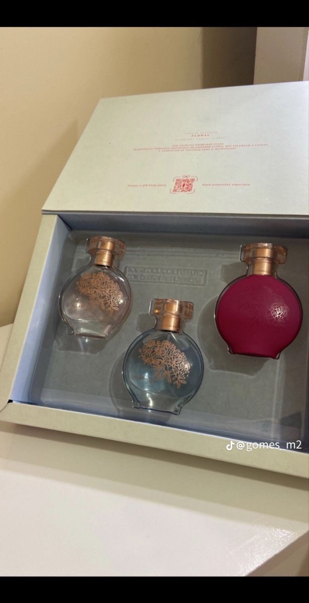 three perfume bottles in a box on top of a counter