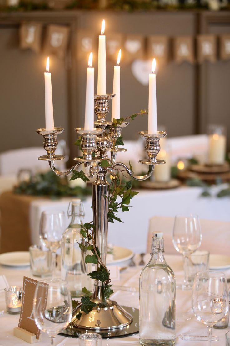 a candelabra filled with candles on top of a white table cloth covered table