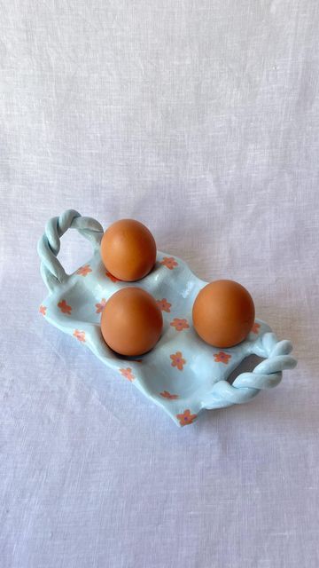 three eggs in a tray on a white tablecloth