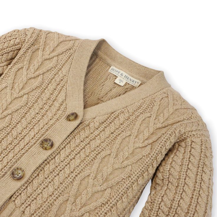 an image of a sweater with buttons on the chest and collaring, in beige