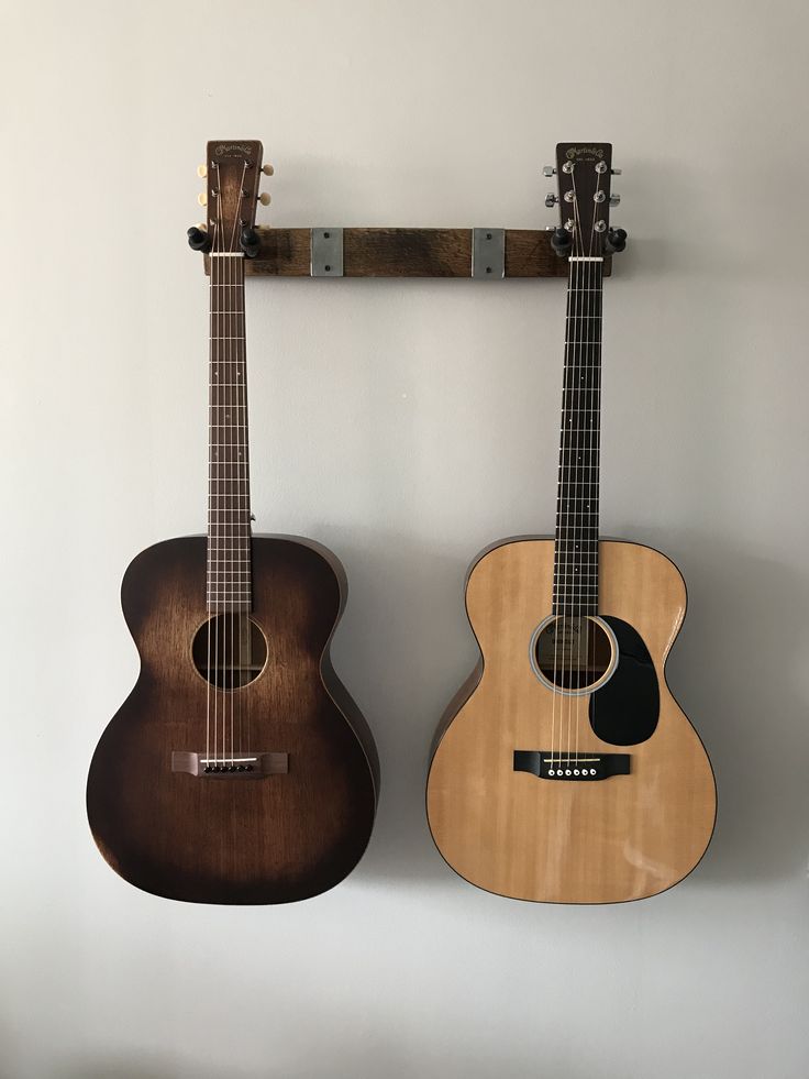 two guitars are hanging on the wall next to each other