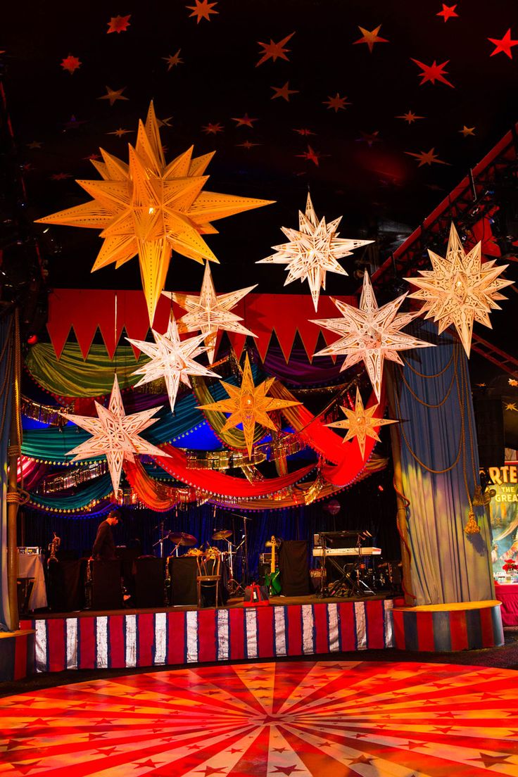 an elaborately decorated stage with stars hanging from the ceiling and lights in the background