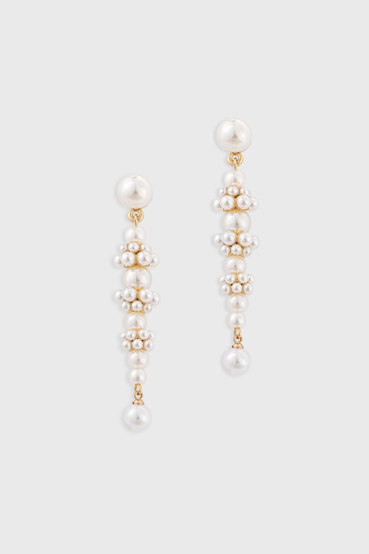 two pairs of earrings with pearls hanging from each ear, one in gold and the other in white