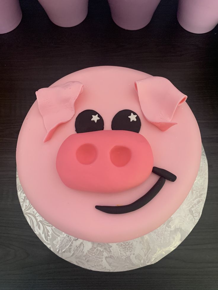 a pink cake with a pig face on it