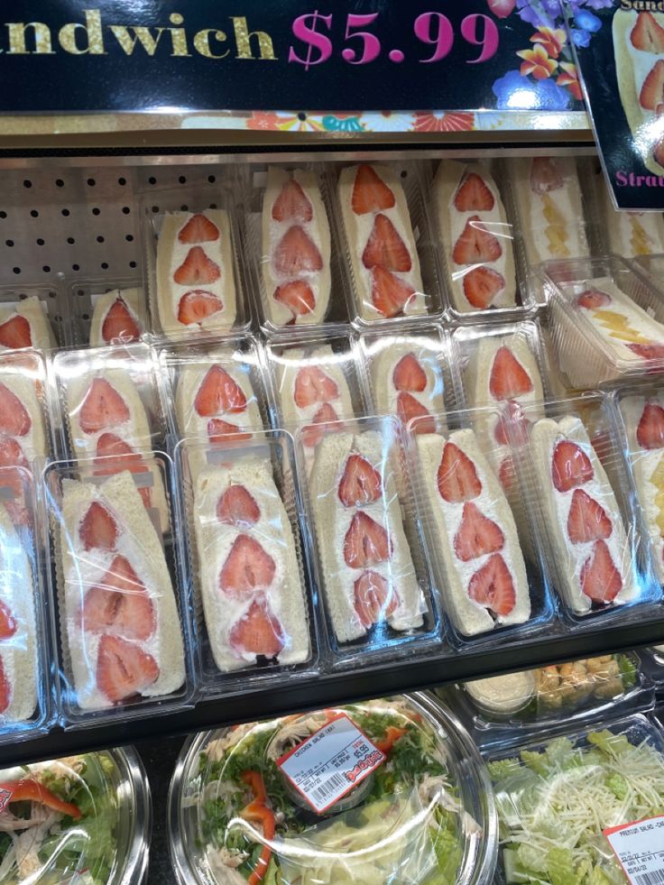 sandwiches and salads are on display in a store