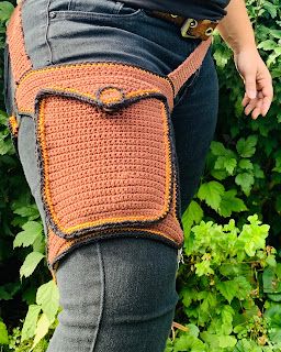 a woman is wearing a crocheted bag on her back and has one hand in the pocket