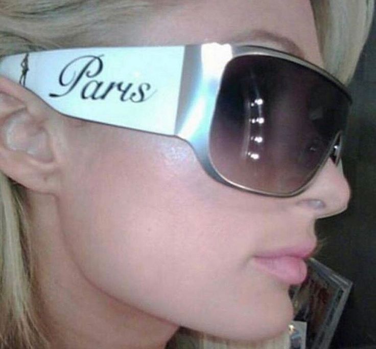 a blonde woman wearing sunglasses with the word paris on it's side and an ear tag attached to her ears