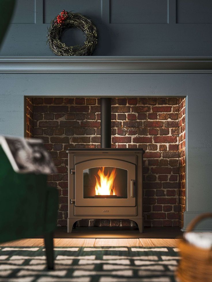 a wood stove in a living room next to a green chair