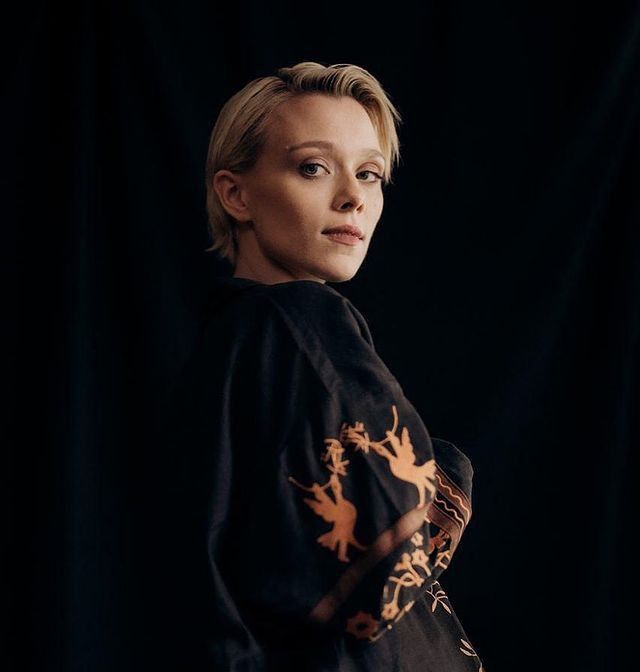 a woman in a black shirt is posing for the camera with her hands on her hips