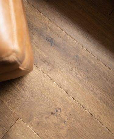 a brown leather chair sitting on top of a wooden floor