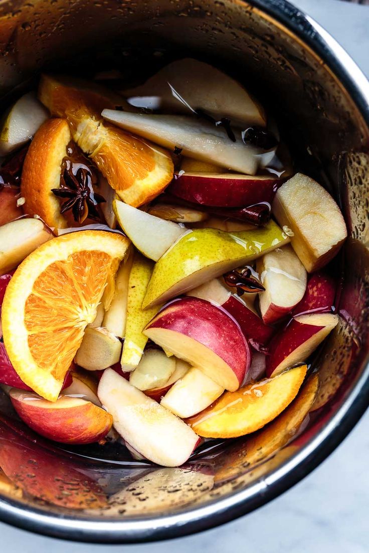 apples, oranges and cranberries are mixed together in the pot