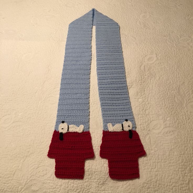 there is a crocheted scarf with sheeps on it and two red shorts