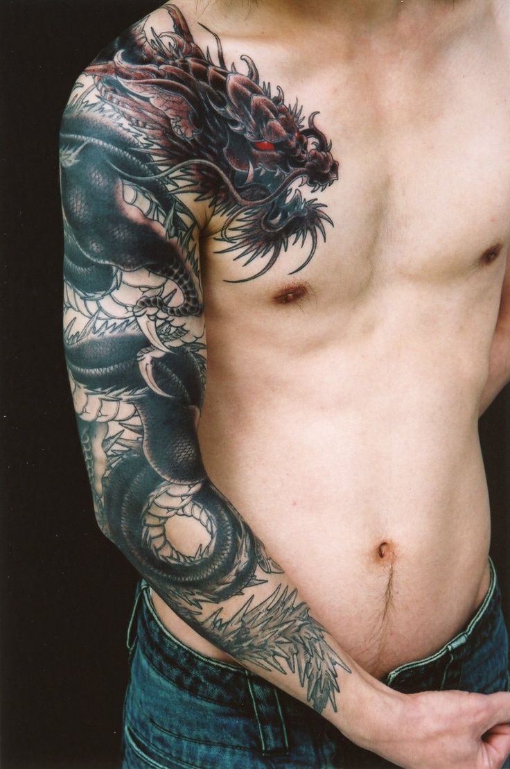 a man with a dragon tattoo on his arm and chest is posing for the camera