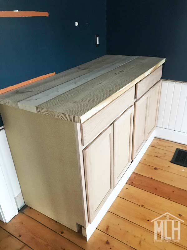 an unfinished kitchen counter with blue walls and wood floors