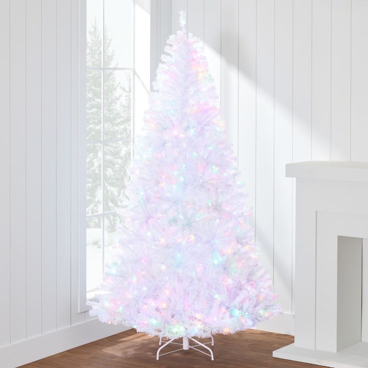 a white christmas tree with multicolored lights is in the corner of a room