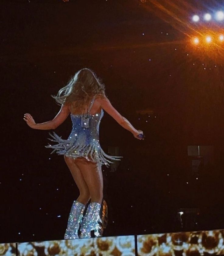 a woman is performing on stage with her legs spread out and she has one leg in the air