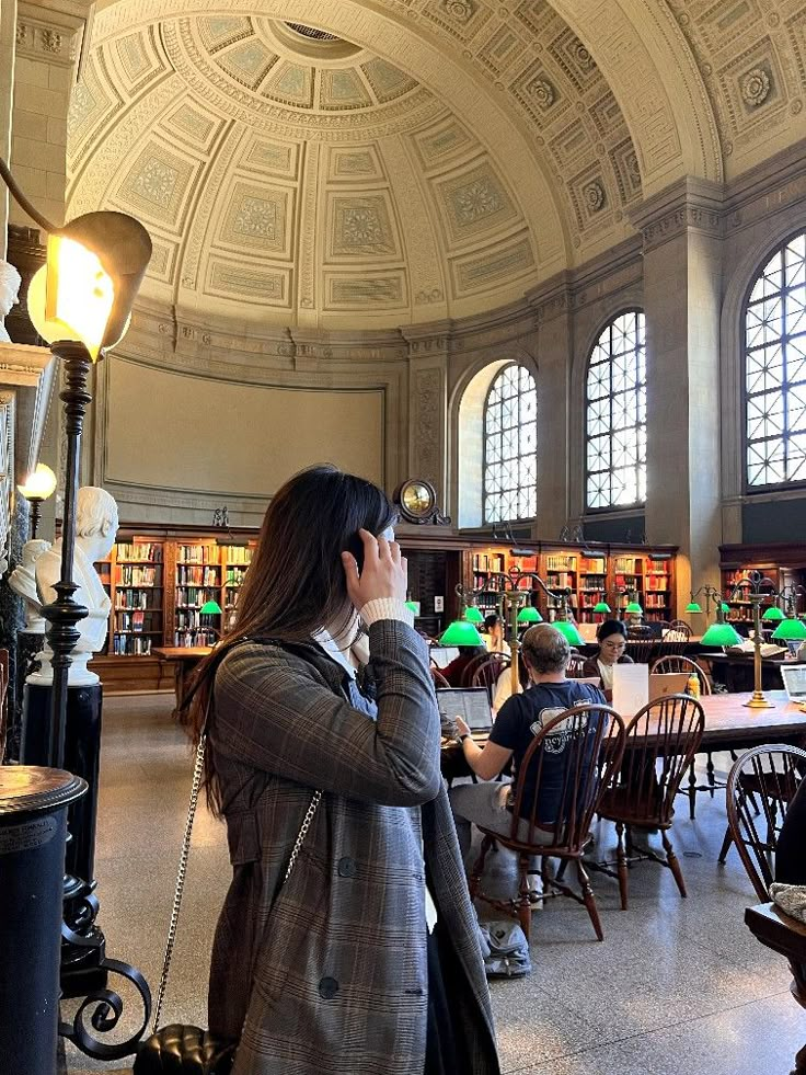 a woman is talking on her cell phone in the library