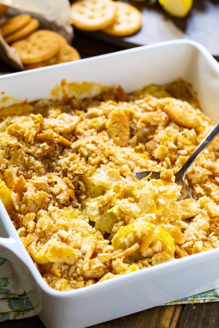 a casserole dish with bread crumbs in it on a table next to crackers