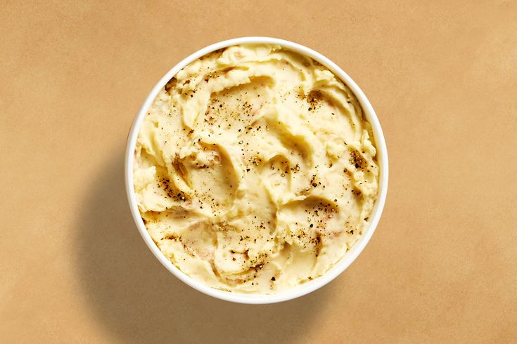 a white bowl filled with mashed potatoes on top of a table